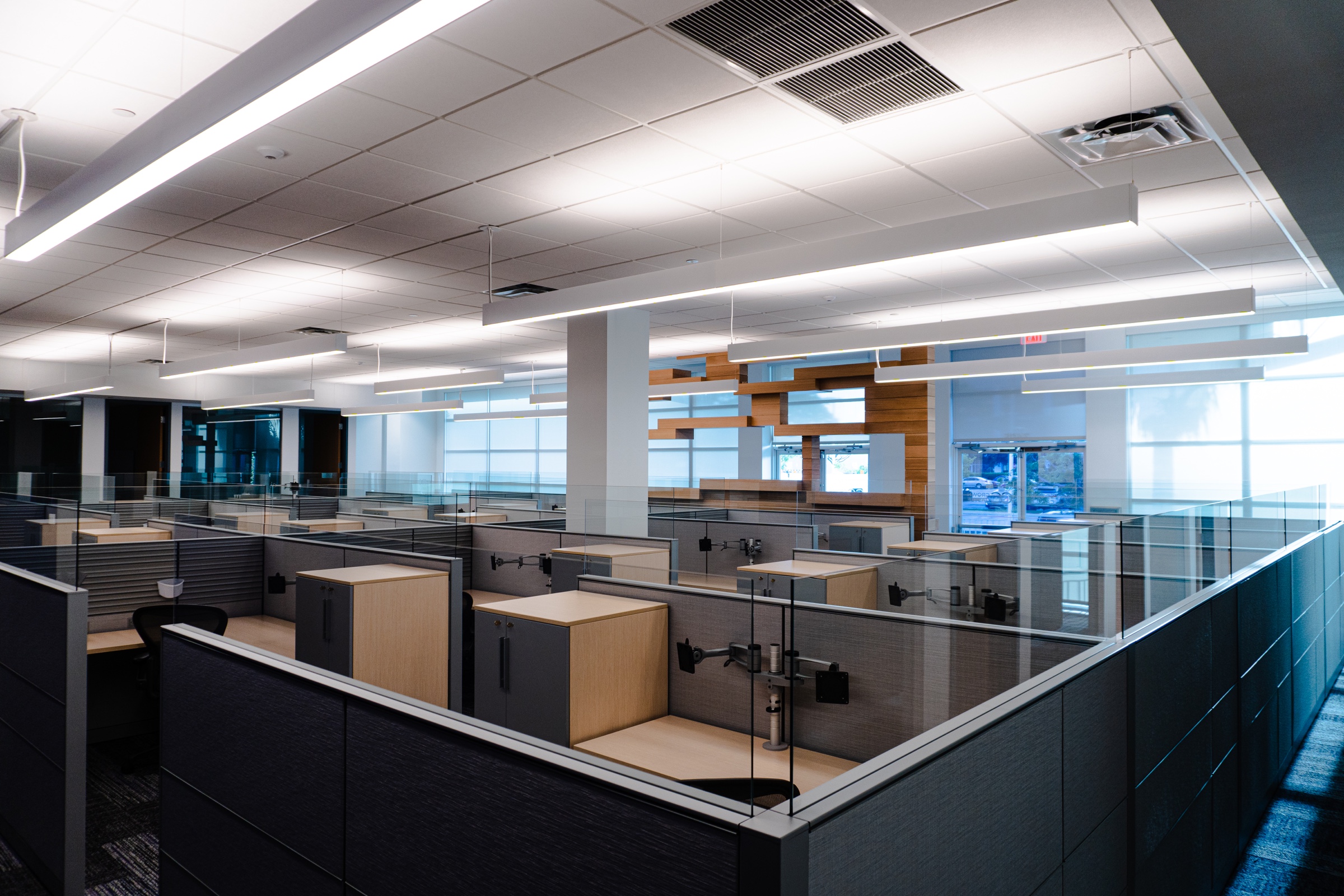 Corporate headquarters workspace with demountable partitions and suspended linear lighting in Doral, Florida